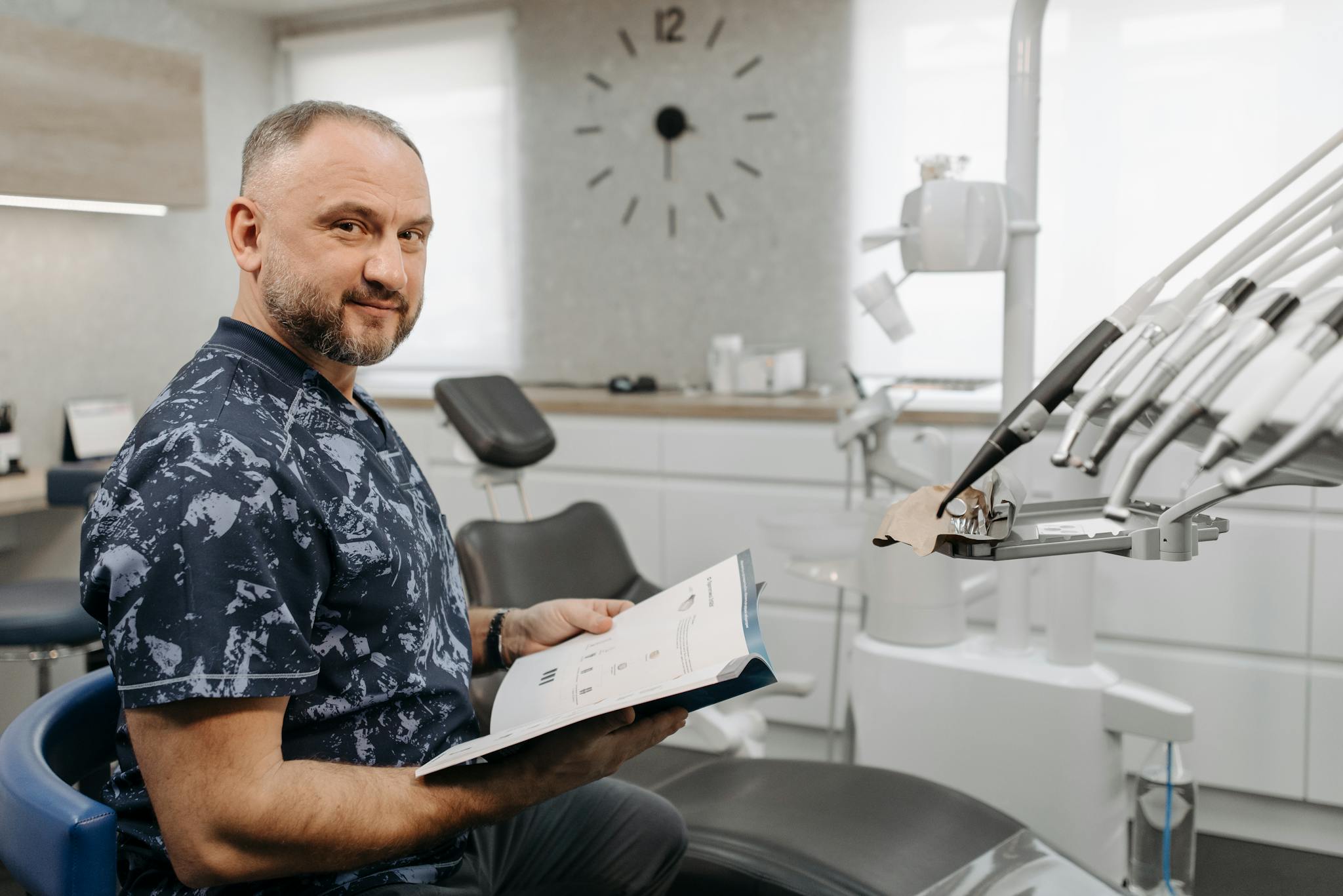 A dentist reviews patient records in a modern dental clinic setting.